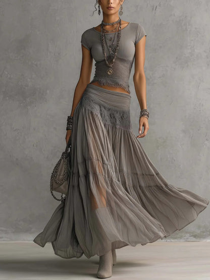 Conjunto de top gris transparente con paneles de encaje y falda larga plisada.