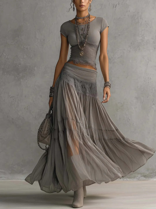 Conjunto de top gris transparente con paneles de encaje y falda larga plisada.