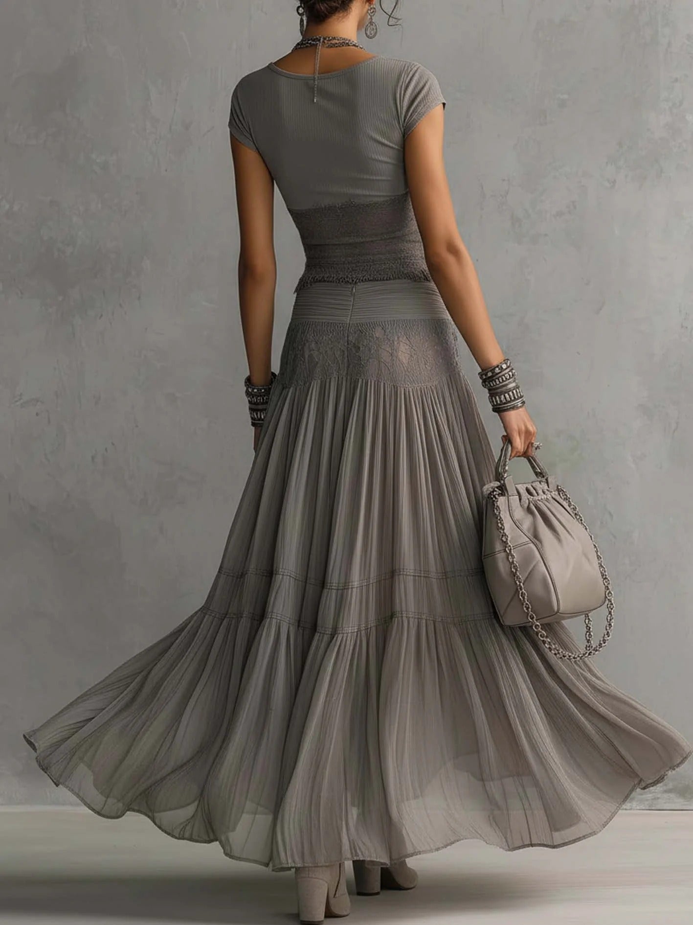 Conjunto de top gris transparente con paneles de encaje y falda larga plisada.