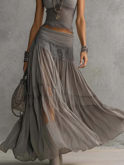 Conjunto de top gris transparente con paneles de encaje y falda larga plisada.